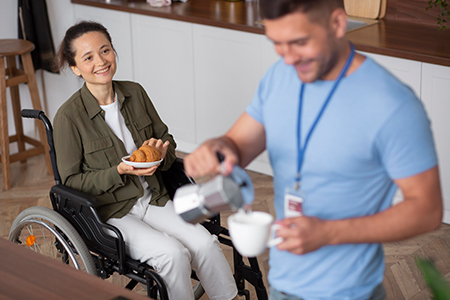 Caregiver serving coffee wheelchair Caregiver serving coffee wheelchair